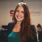 A woman wearing a green shirt is smiling.