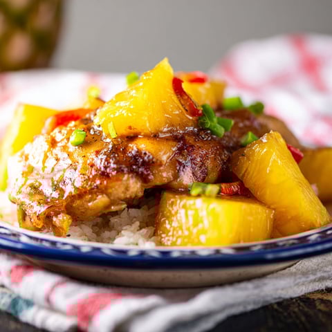A plate of chicken with pineapple and brown sugar.